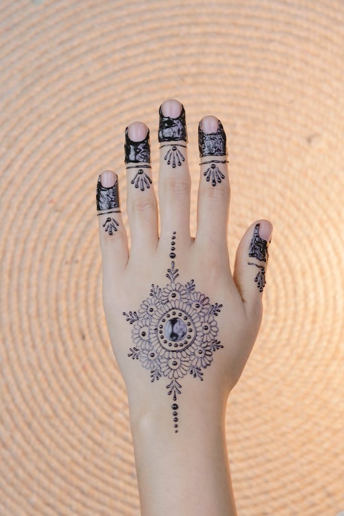 Intricate henna design on a woman's hand, showcasing cultural artistry indoors.