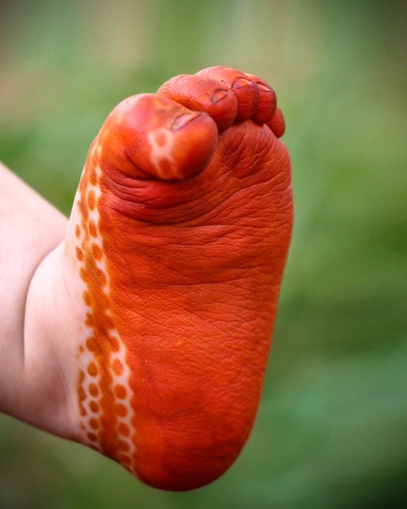 Close-up of a child's foot with henna designs, showcasing cultural art.
