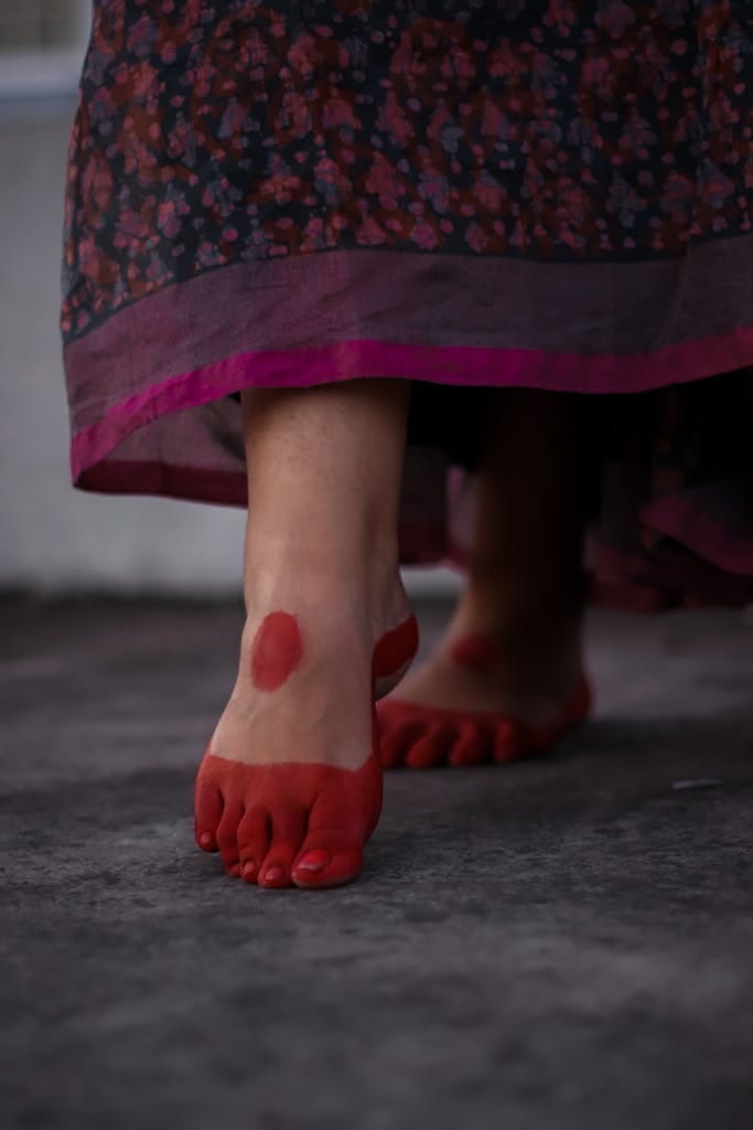 Close-up of red-stained feet with Mahavar in Dhaka, showcasing traditional art.