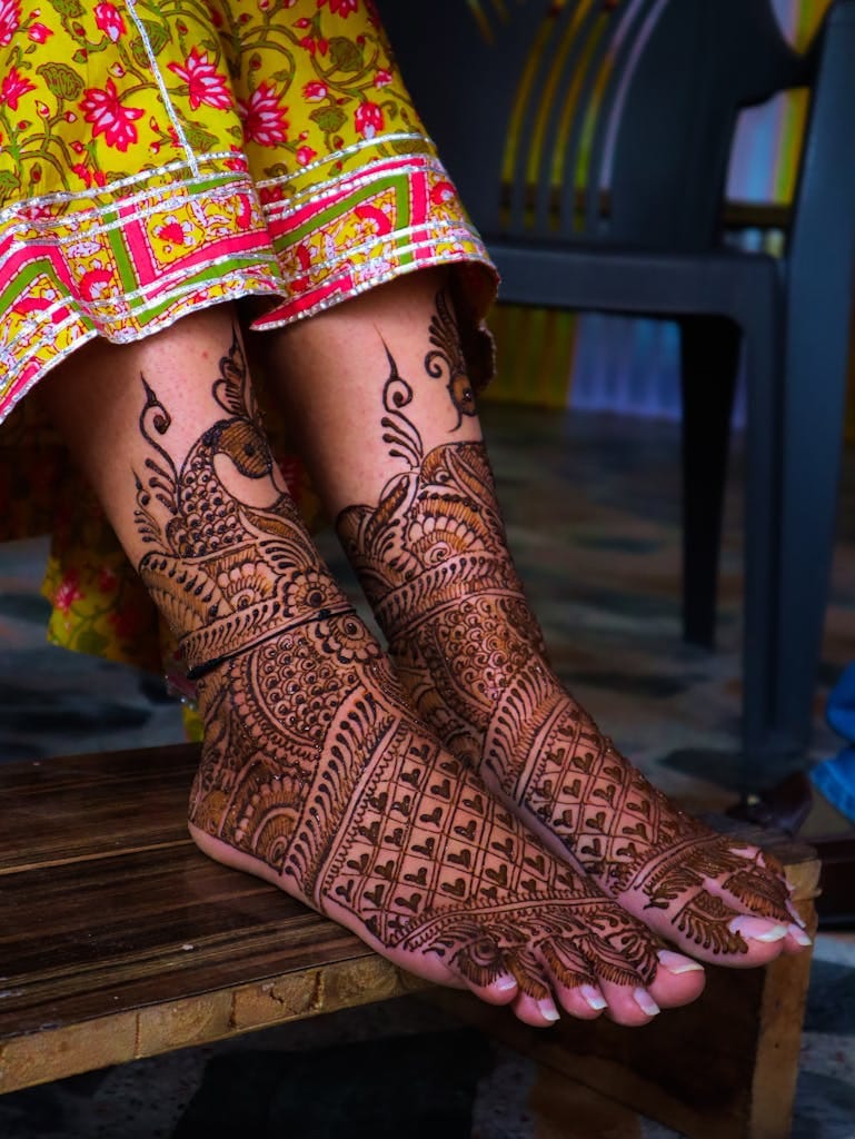 Detailed mehendi designs adorn the feet of an Indian bride, highlighting tradition.