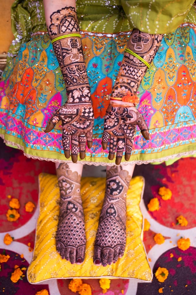 Vibrant photo of intricate henna tattoos on Indian woman's hands and feet, Bharatpur, India.